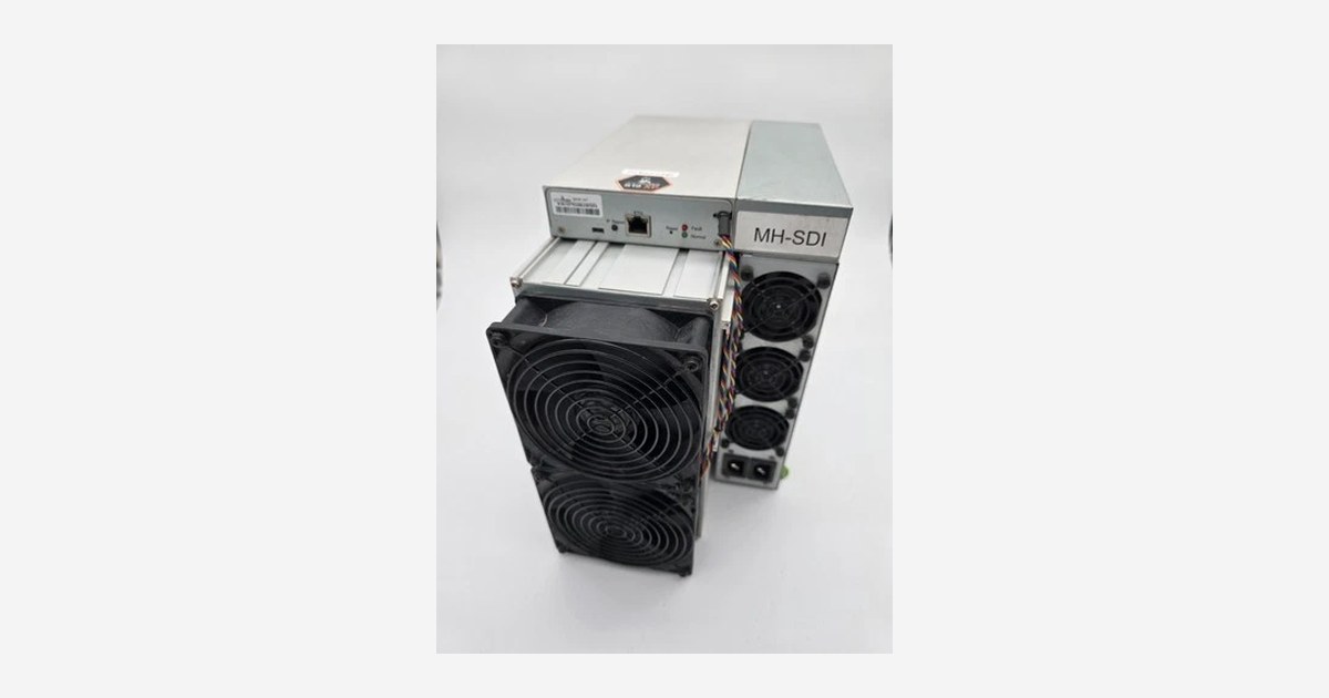 A refurbished Bitmain Antminer S19 XP 141 TH/s air-cooled SHA-256 Bitcoin miner photographed in our own inventory, showing the front fan stack and the power supply mounted on top of the chassis. This is the used machine compared against a new Antminer S21 Pro 245T in this article.
