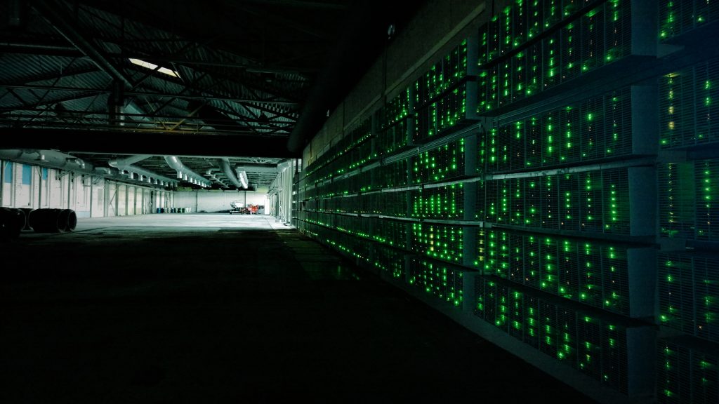 Rows of ASIC Bitcoin mining rigs in a mining farm