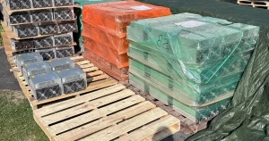 Pallets of used Antminer S19s shrink-wrapped for freight, outdoors.