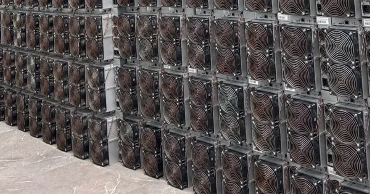 Several hundred used Antminer S19s stacked in storage.