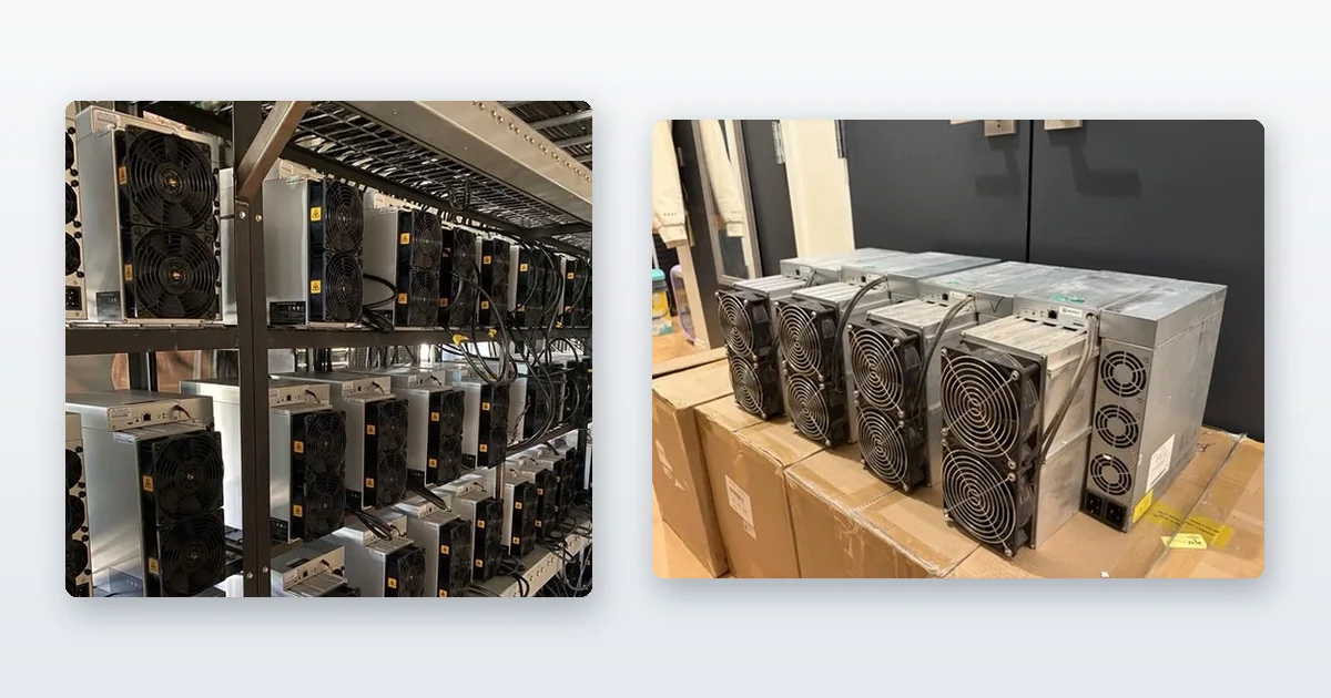 Antminer S19s racked on steel shelving and running and miners staged on shipping crates in a warehouse.