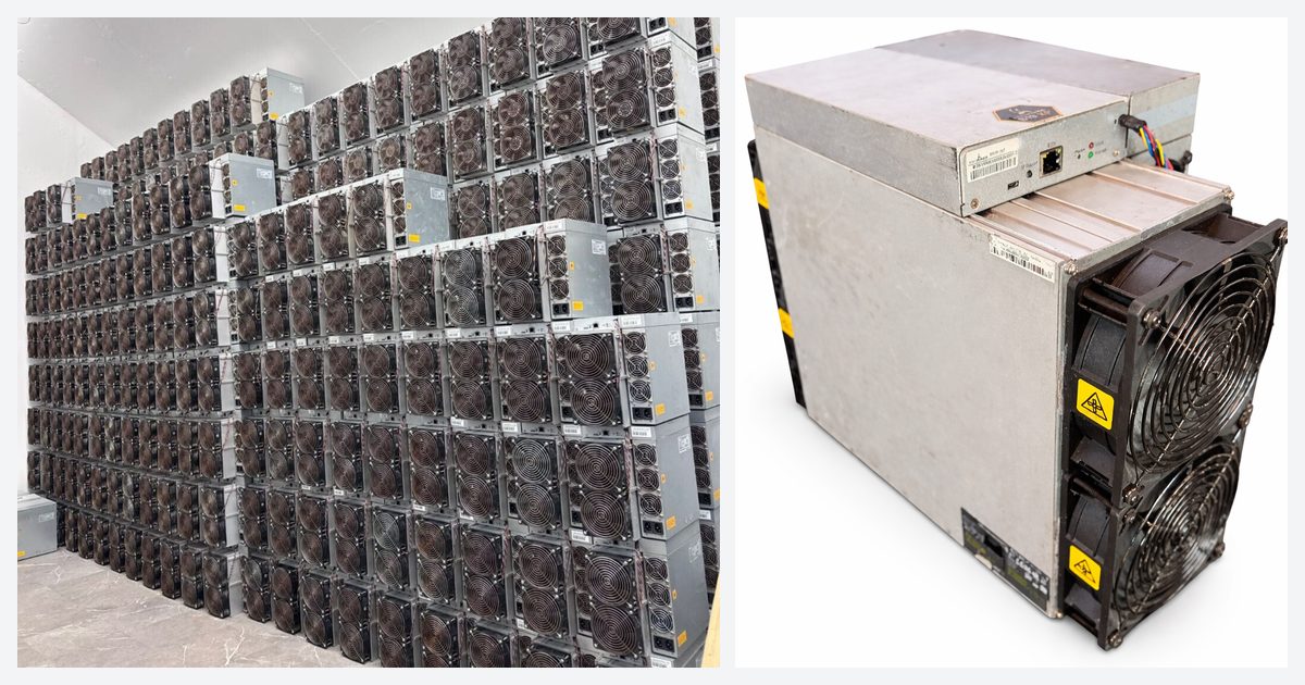 Used Antminer S19 units stacked several rows high against a warehouse wall, beside a single used S19k Pro standing on a plank floor with its power supply attached.