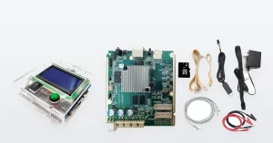 A universal Antminer hashboard test fixture in its clear acrylic case, with a blue LCD and a green start button, beside a Bitmain Antminer E9 hashboard test fixture main board and its accessory kit of leads, SD card, mains adapter and crocodile clips.