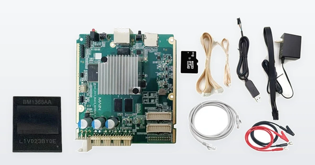 A Bitmain BM1368AA mining ASIC chip beside a Bitmain Antminer E9 hashboard test fixture: the green main board with its heatsink, and the kit that ships with it - SD card, ribbon and Ethernet leads, a USB-serial cable, a mains adapter and crocodile test leads.