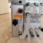 The rear panel of the Antminer S19 XP Hyd: quick-release coolant fittings, clear hoses and the control board's ports and SD slot.